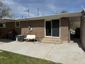Back of property with a patio, central AC, entry steps, and brick siding