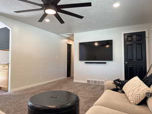 Carpeted living area featuring recessed lighting, visible vents, ceiling fan, and baseboards