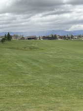 Surrounding community featuring a mountain view and a lawn