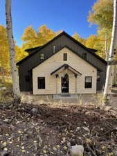 Bungalow featuring board and batten siding and stone siding