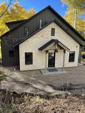 Back of house featuring board and batten siding and stone siding