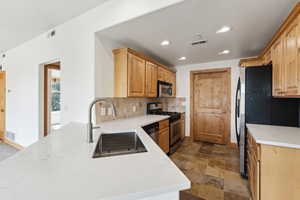Kitchen featuring quartz countertops, stainless steel appliances, and a sink