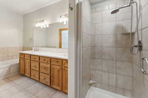 Master Bathroom with double sinks, quartz countertop, walk-in closet, tile patterned floors, toilet and a garden tub