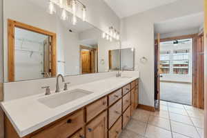 Master Bathroom with double sinks, quartz countertop, walk-in closet, tile patterned floors, toilet and a garden tub