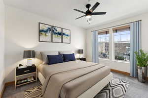 VIRTYALLY STAGED - Carpeted bedroom featuring a ceiling fan and baseboards
