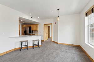 Kitchen featuring a sink, quartz countertops, stainless steel refrigerator with ice dispenser and counter seating