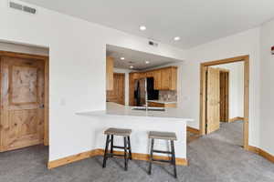 Kitchen featuring quartz countertops, baseboards, and refrigerator with ice dispenser