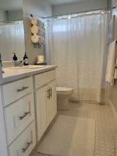 Bathroom with tile patterned floors, toilet, and vanity