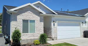View of front of house with a garage, concrete driveway, and central air condition unit