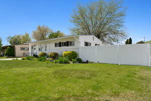 View of front facade with fence, board and batten siding, and a front yard