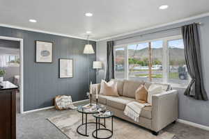 Living area featuring baseboards, ornamental molding, carpet, and a wealth of natural light