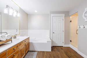Solid wood double vanity, soaker tub, wood grain tile, and ensuite water closet.