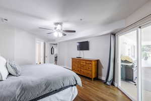 Owner's suite with large slider to balcony, large walk-in closet, and solid wood dresser with TV.