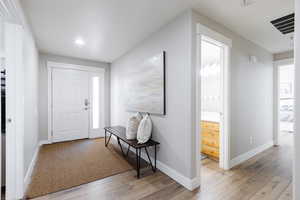 Foyer entrance with decorative bench and LVP flooring.