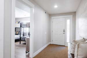 Entry way with recessed lighting and LVP flooring.