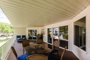 Spacious patio with large banister, built in gas line for BBQ, patio table, with view of waterfall pool and playground.