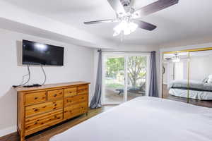 Owner's suite with large slider to balcony, large walk-in closet, and solid wood dresser with TV.
