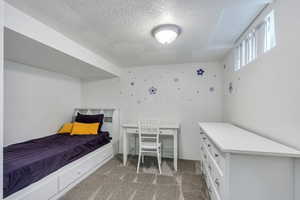 Bedroom featuring carpet and a textured ceiling