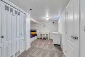 Bedroom featuring light colored carpet, a textured ceiling, baseboards, and visible vents