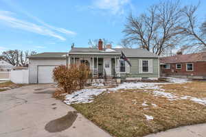 Ranch-style home with fence, an attached garage, a porch, a chimney, and driveway