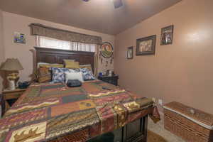 Bedroom with ceiling fan, carpet flooring, and lofted ceiling
