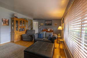 Living area featuring visible vents, light wood-style flooring, and stairway