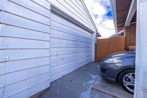 View of property exterior featuring fence and a garage