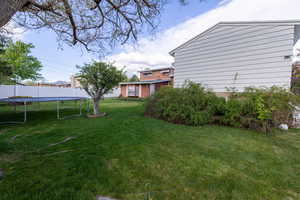 View of yard featuring fence and a trampoline