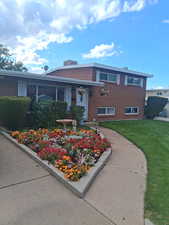 Split level home with brick siding and a front lawn