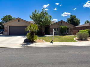 Ranch-style home featuring stucco siding, a front yard, driveway, an attached garage, and a tile roof