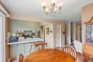 Dining room with stairs, baseboards, a chandelier, and light wood-type flooring