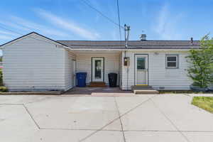 Back of property with a shingled roof and entry steps
