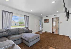 Living area with recessed lighting and carpet flooring