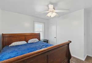 Carpeted bedroom featuring baseboards and ceiling fan