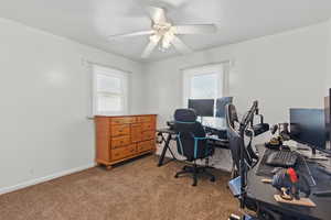 Carpeted office space featuring baseboards and a ceiling fan
