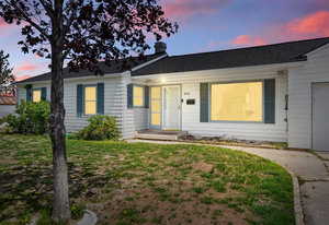 Ranch-style home featuring a garage, driveway, and a yard