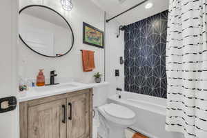 Main Bathroom with toilet, shower / bathtub combination with curtain, vanity, and recessed lighting