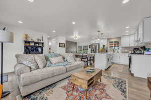 Living room with light wood-type flooring and recessed lighting