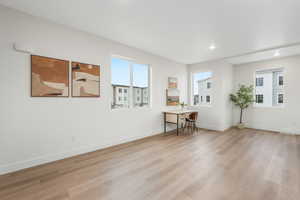 Spare room featuring light wood-type flooring, baseboards, and recessed lighting