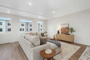 Living room featuring baseboards, wood finished floors, and recessed lighting