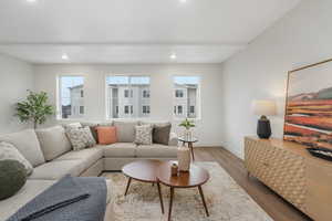 Living area featuring a healthy amount of sunlight, wood finished floors, and recessed lighting
