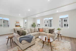Living room with recessed lighting, wood finished floors, a wealth of natural light, and baseboards