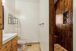 Bathroom with tile patterned flooring, vanity, toilet, baseboards, and visible vents