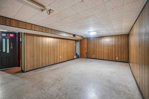 Family room featuring light floors and wood walls
