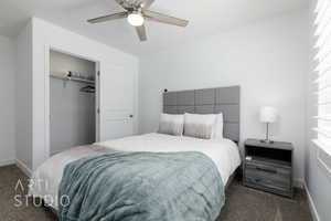 Bedroom with dark carpet, ceiling fan, a closet, and baseboards