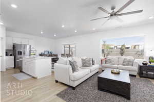 Living area with recessed lighting and light wood-style flooring