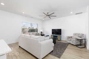 Living room featuring recessed lighting, visible vents, ceiling fan, and light wood-style flooring