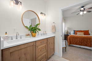 Ensuite bathroom with ensuite bathroom, a sink, ceiling fan, and double vanity