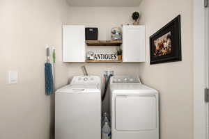 Laundry area with separate washer and dryer and cabinet space