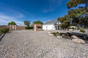 Back of property featuring an outdoor structure, a shed, and fence